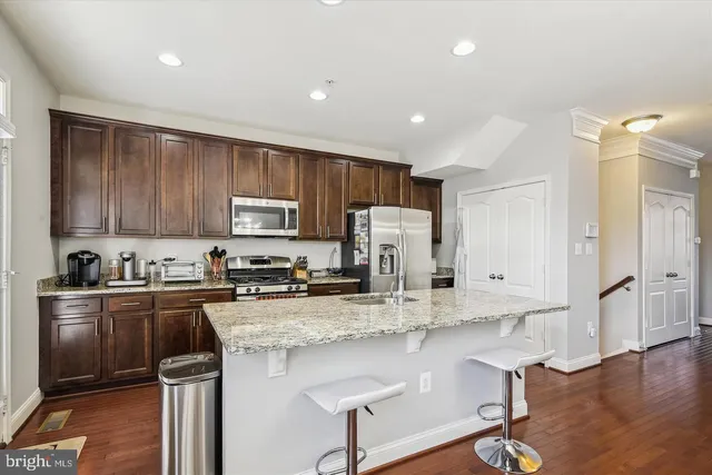 a kitchen with stainless steel appliances granite countertop a stove refrigerator sink and cabinets