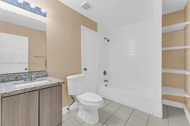 a bathroom with a granite countertop sink a toilet and shower