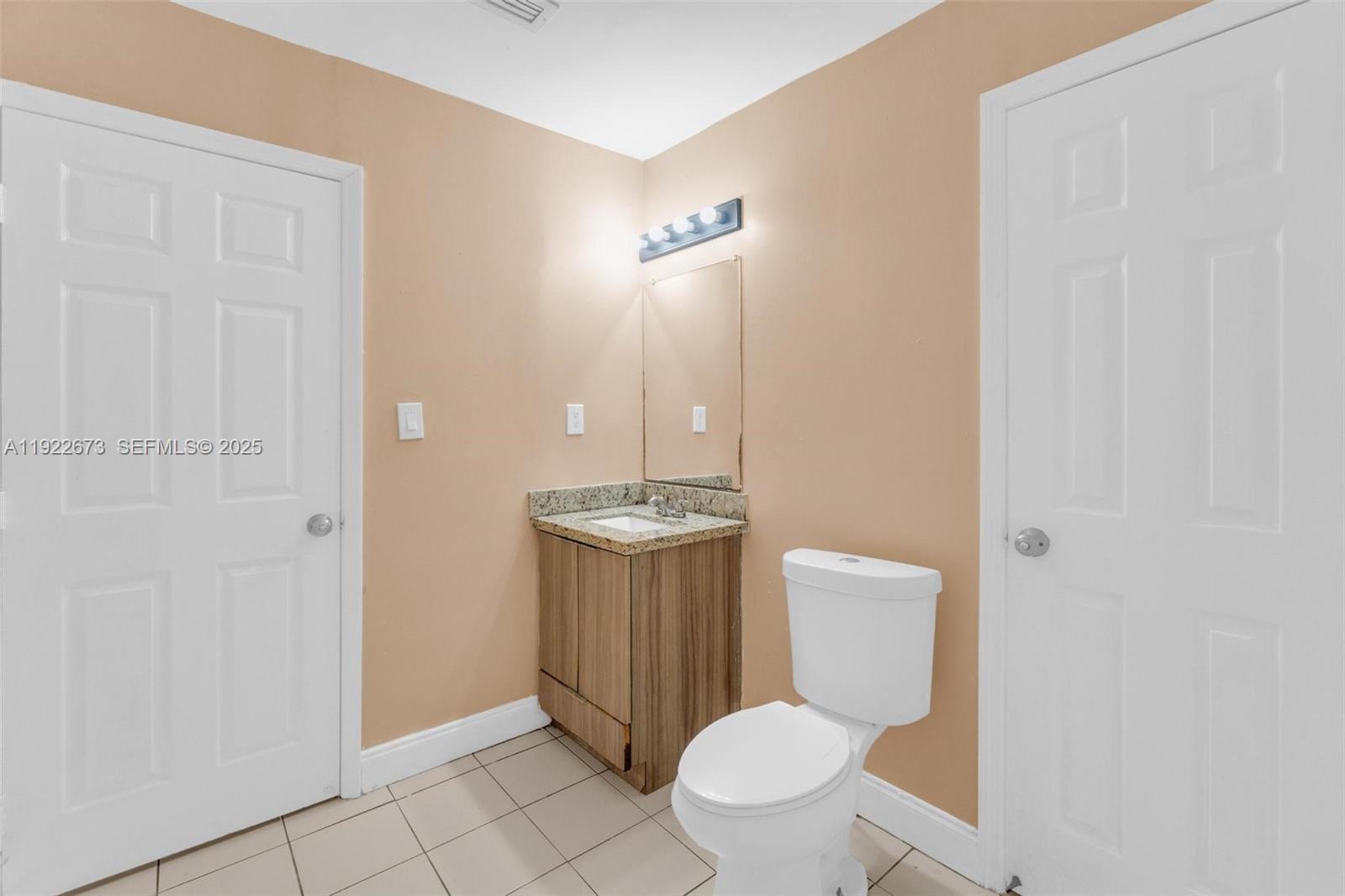 10220 Southwest 178th Street, Unit 10220 Miami, FL 33157 - Photo 19 of 25 a bathroom with a toilet a sink and mirror