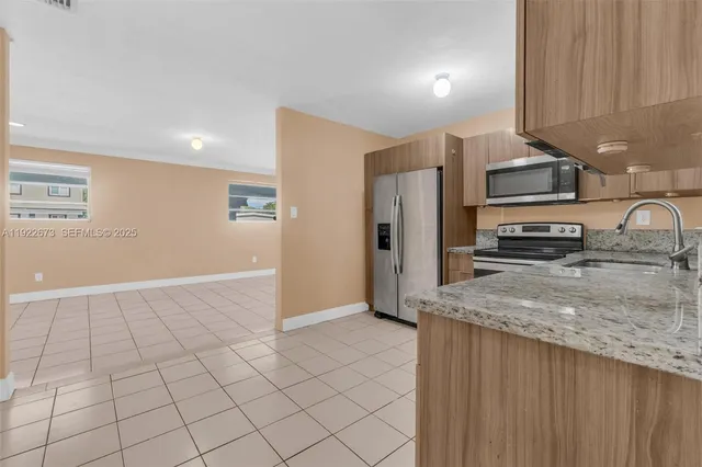 a kitchen with stainless steel appliances granite countertop a refrigerator and a sink