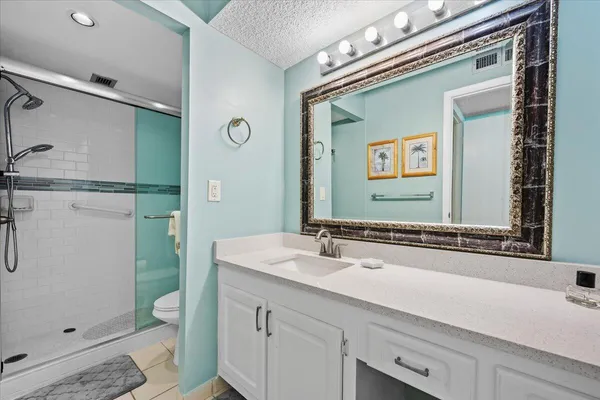 a bathroom with a sink a toilet and shower