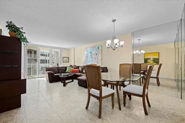 a dining room with furniture a chandelier and window