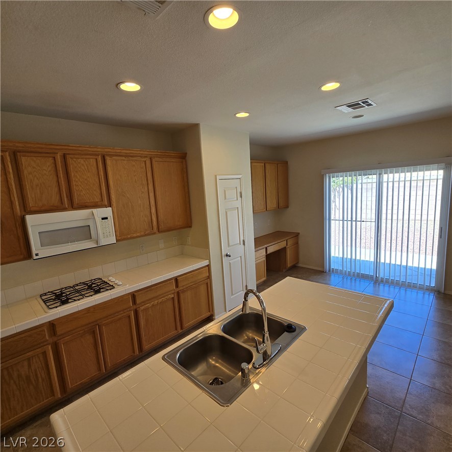 9234 Kingston Road Henderson, NV 89074 - Photo 19 of 38 A well-appointed kitchen features a central island with a double sink and ample cabinetry.