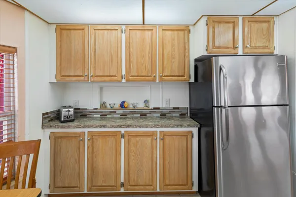 a kitchen with stainless steel appliances granite countertop a refrigerator a stove and a sink with wooden floor