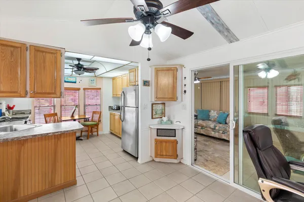 a kitchen with stainless steel appliances kitchen island granite countertop a refrigerator a sink a stove and white cabinets