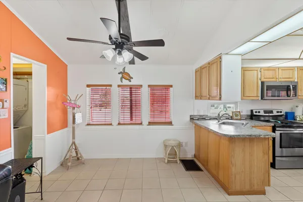 a kitchen with a sink a counter top space cabinets and stainless steel appliances