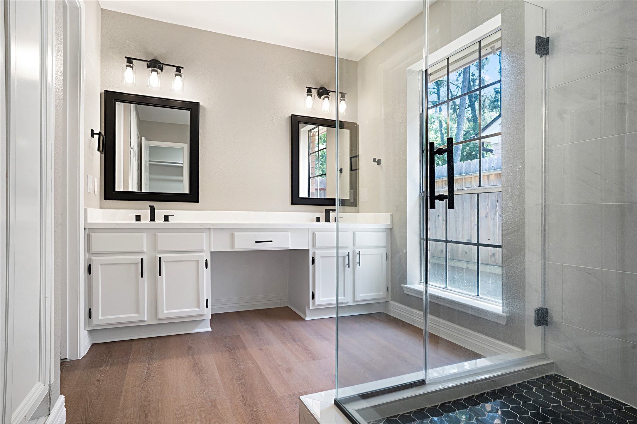 3 Still Corner Place Spring, TX 77381 - Photo 12 of 42 Primary bath with dual sinks, white quartz countertops, modern fixtures, and a spacious vanity offering ample storage. LVP flooring continues throughout for a cohesive look.