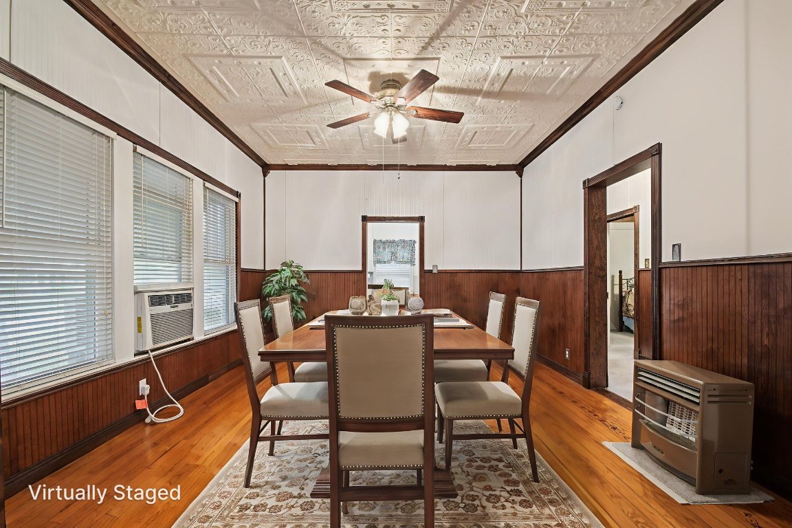 611 North Main Street Elgin, TX 78621 - Photo 14 of 34 Virtually staged dining room with ornamental molding, an ornate ceiling, light wood-style flooring, wood walls, and wainscoting