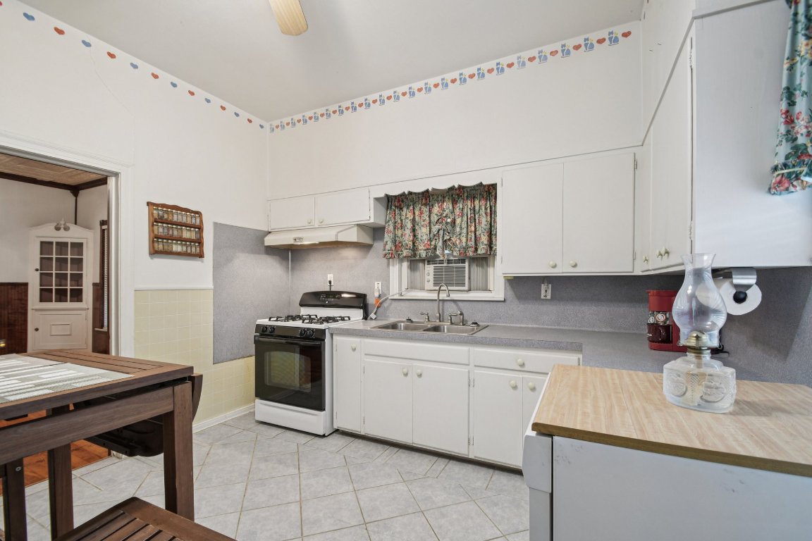 611 North Main Street Elgin, TX 78621 - Photo 20 of 34 Kitchen with gas range, white cabinetry, light countertops, and light tile patterned floors
