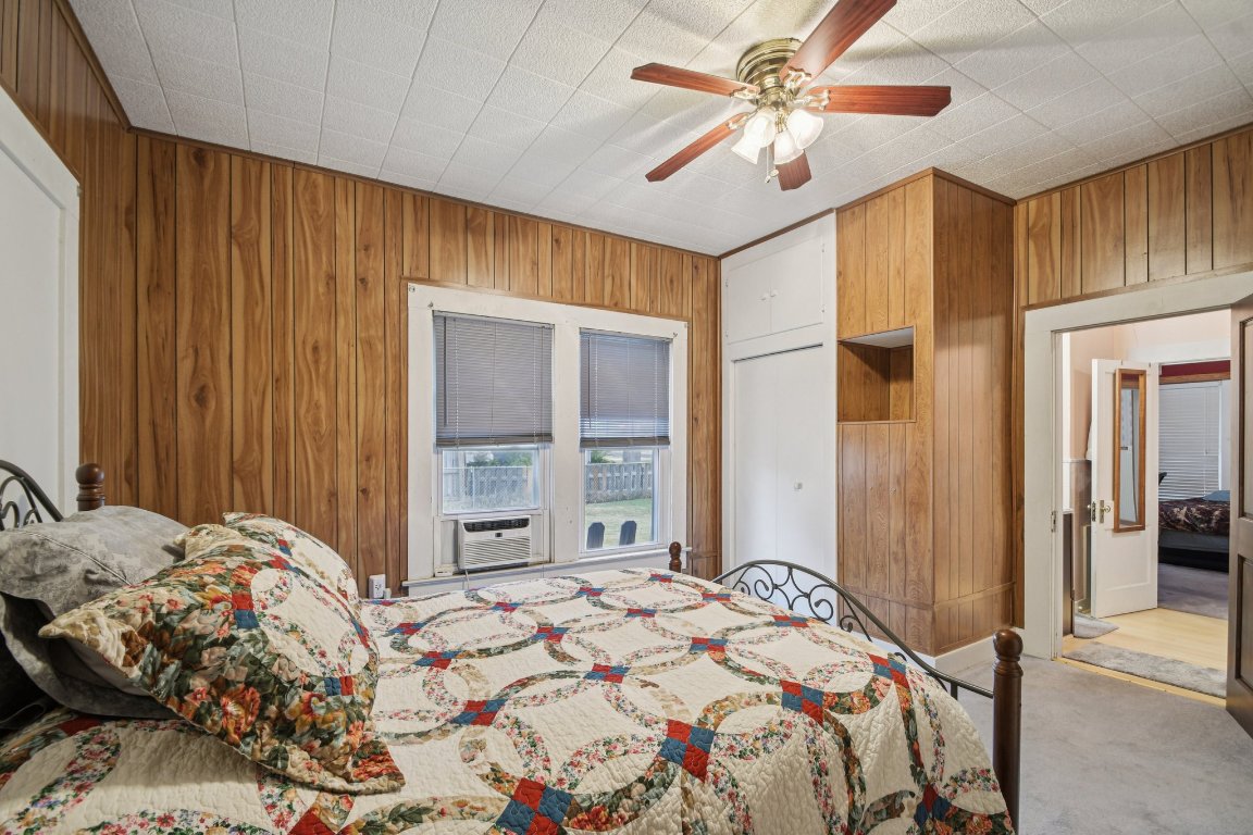 611 North Main Street Elgin, TX 78621 - Photo 22 of 34 Bedroom with wooden walls, carpet floors, ceiling fan, and a closet