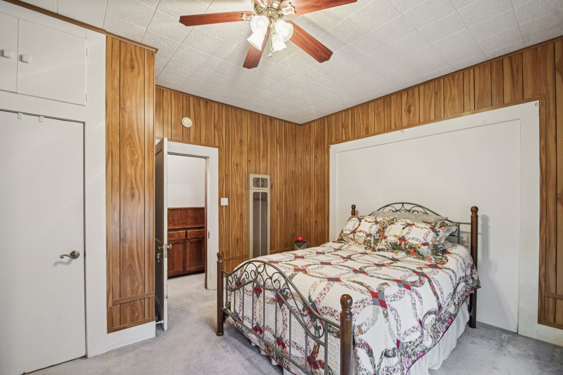 611 North Main Street Elgin, TX 78621 - Photo 24 of 34 Bedroom featuring wood walls, carpet, and ceiling fan