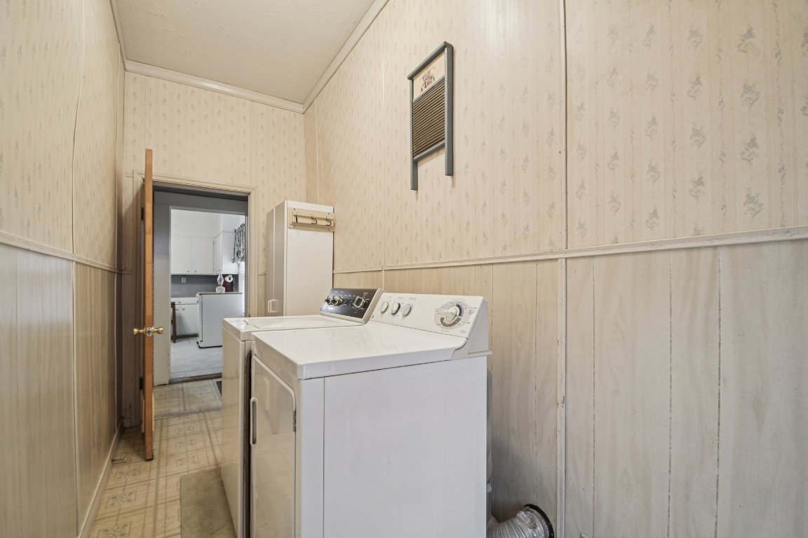 611 North Main Street Elgin, TX 78621 - Photo 30 of 34 Laundry area featuring crown molding, wallpapered walls, wainscoting, and washer and clothes dryer