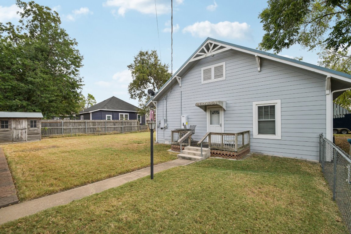 611 North Main Street Elgin, TX 78621 - Photo 33 of 34 Back of property with a fenced backyard and a shed