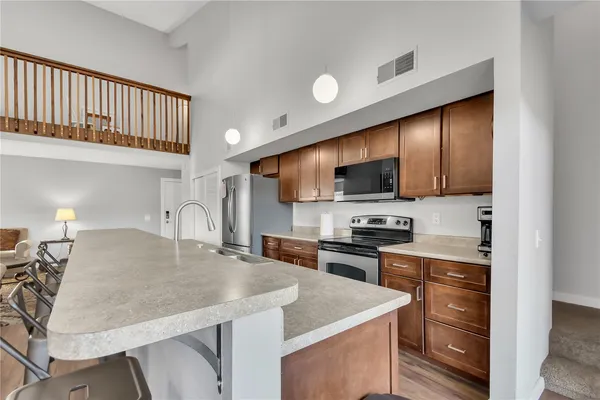 a kitchen with stainless steel appliances granite countertop a stove a sink and a microwave