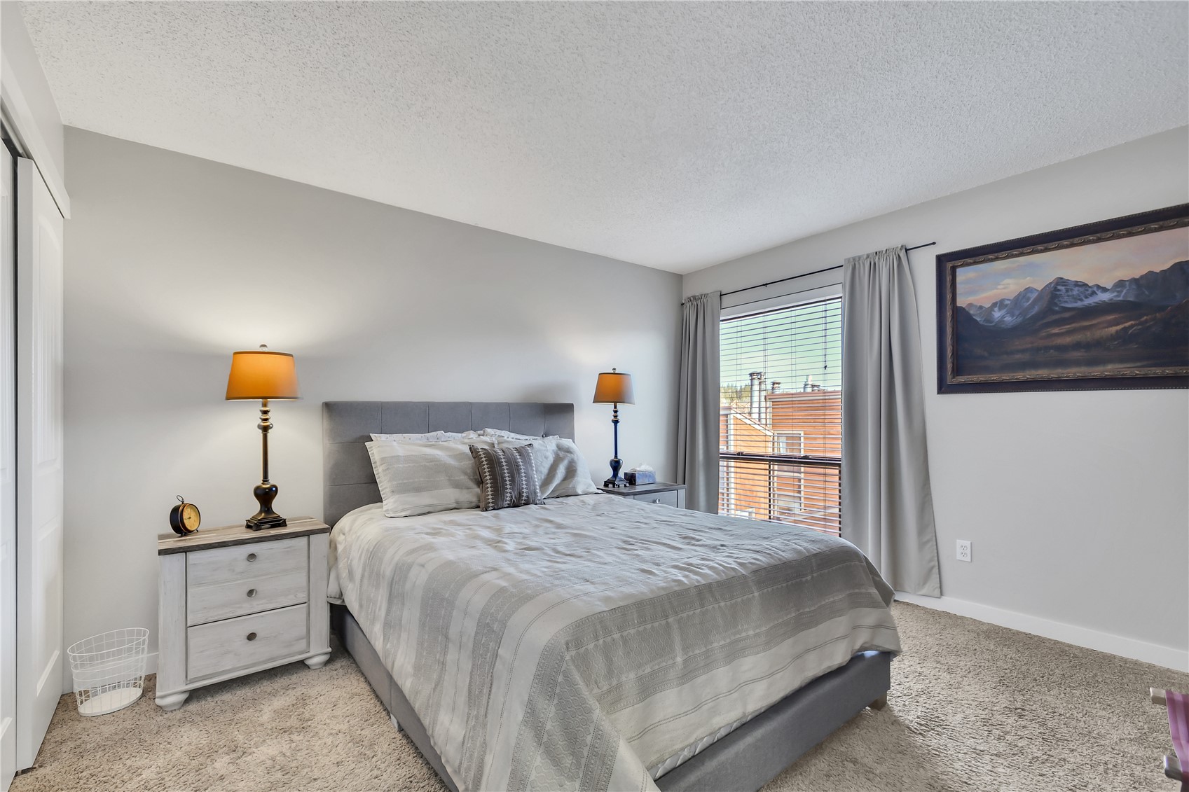 2710 Ryan Gulch Road, Unit 2731 Silverthorne, CO 80498 - Photo 21 of 39 a bedroom with a large bed and a lamp on dresser
