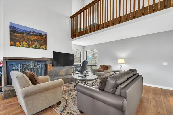 a living room with furniture a flat screen tv and a fireplace