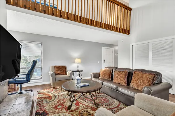 a living room with furniture a rug and a flat screen tv