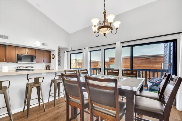 a view of a dining room with furniture a chandelier and wooden floor