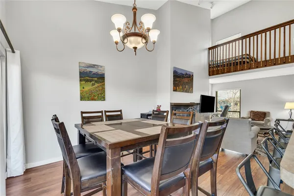 a view of a dining room with furniture a chandelier and wooden floor
