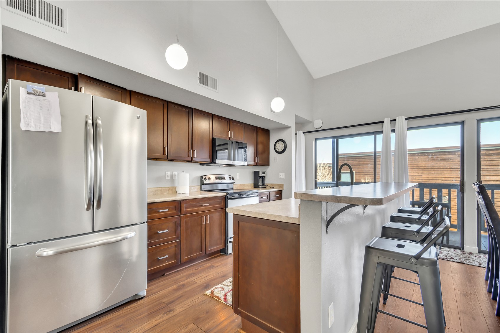 2710 Ryan Gulch Road, Unit 2731 Silverthorne, CO 80498 - Photo 8 of 39 a kitchen with stainless steel appliances granite countertop a refrigerator a stove top oven a sink dishwasher and white cabinets with wooden floor