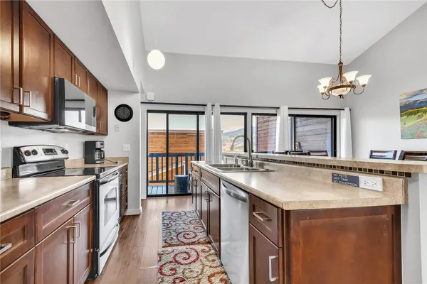 a kitchen with stainless steel appliances granite countertop a sink a stove and a refrigerator