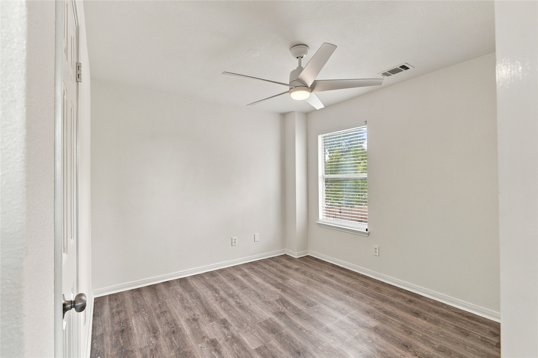 910 Point Run Drive Pflugerville, TX 78660 - Photo 24 of 39 Rich wood flooring anchors this versatile space, illuminated by natural light from a large window.