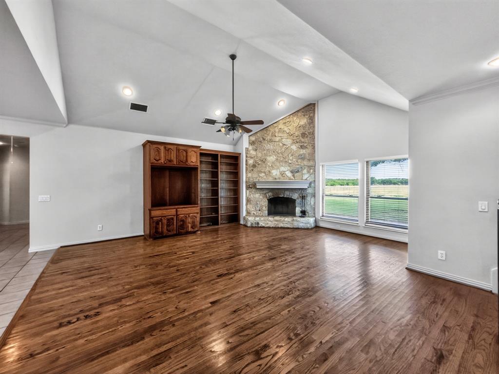 1255 Vineyard Road Gunter, TX 75058 - Photo 5 of 20 an empty room with fireplace wooden floor and windows