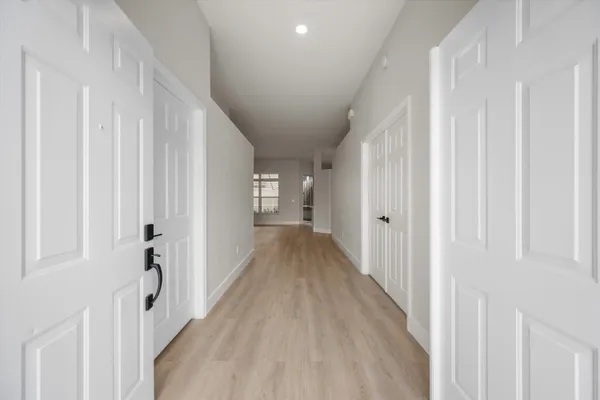 a view of a hallway with wooden floor and entryway