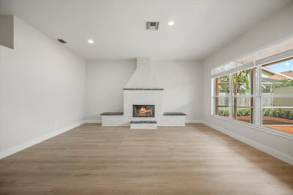 a view of an empty room with a window and a fireplace
