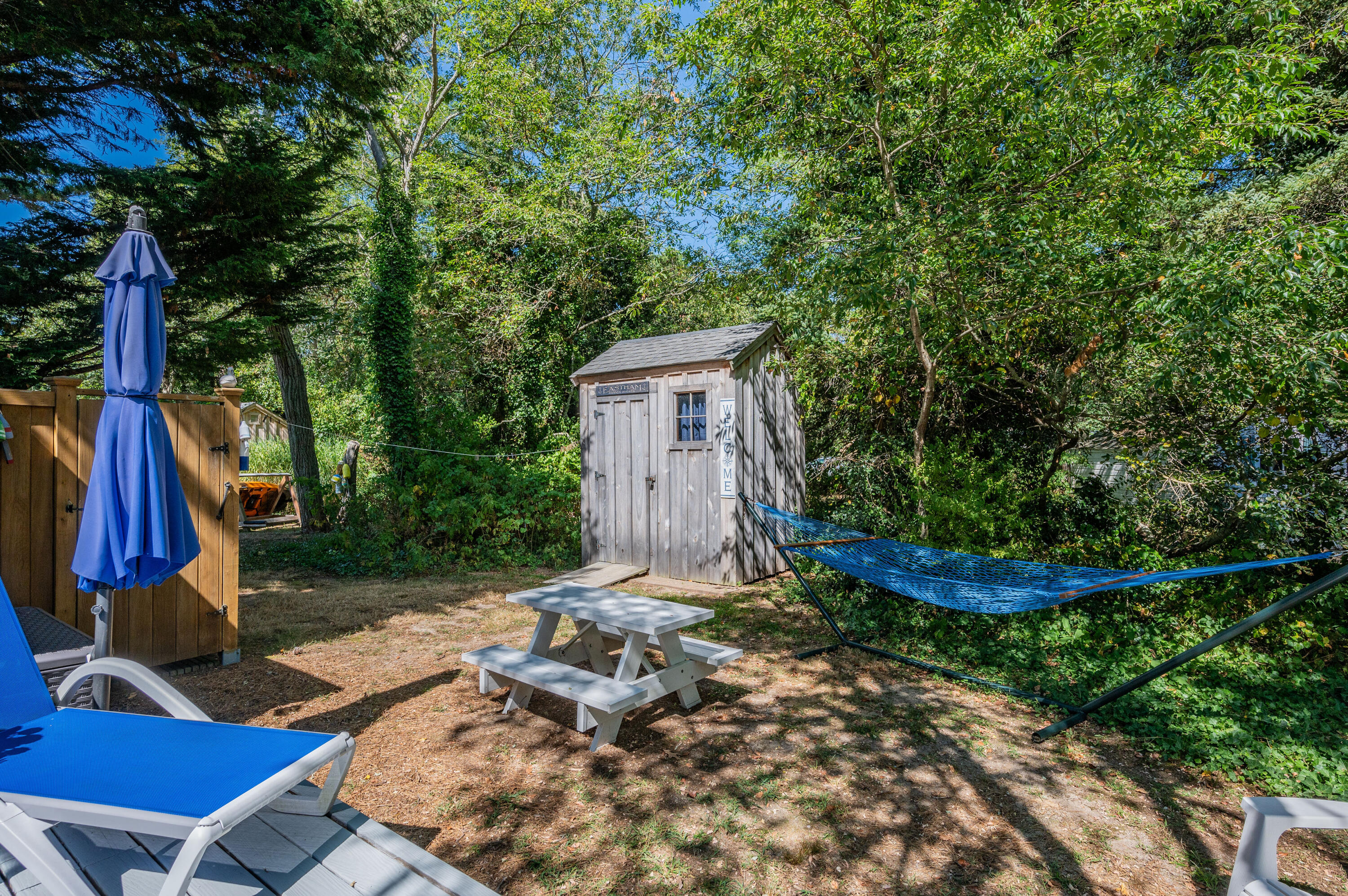 785 State Highway, Unit 9 Eastham, MA 02642 - Photo 19 of 30 a view of a backyard with plants and a slide