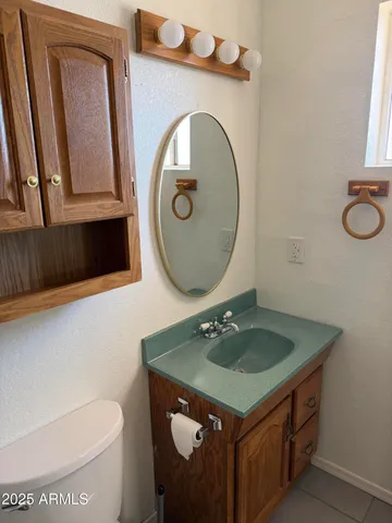 a bathroom with a sink a toilet and a mirror