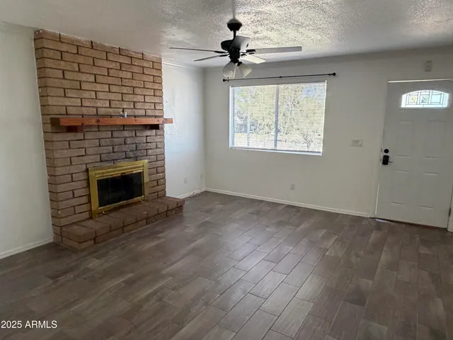 wooden floor fireplace and windows in an empty room