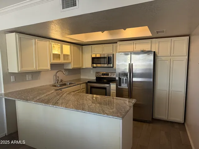 a kitchen with granite countertop a refrigerator and a sink