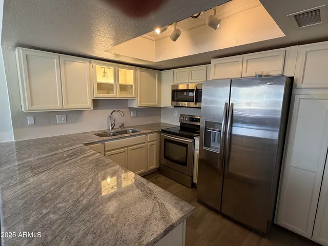 a kitchen with a refrigerator a sink and cabinets