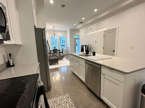 a large white kitchen with a lot of counter space and a sink