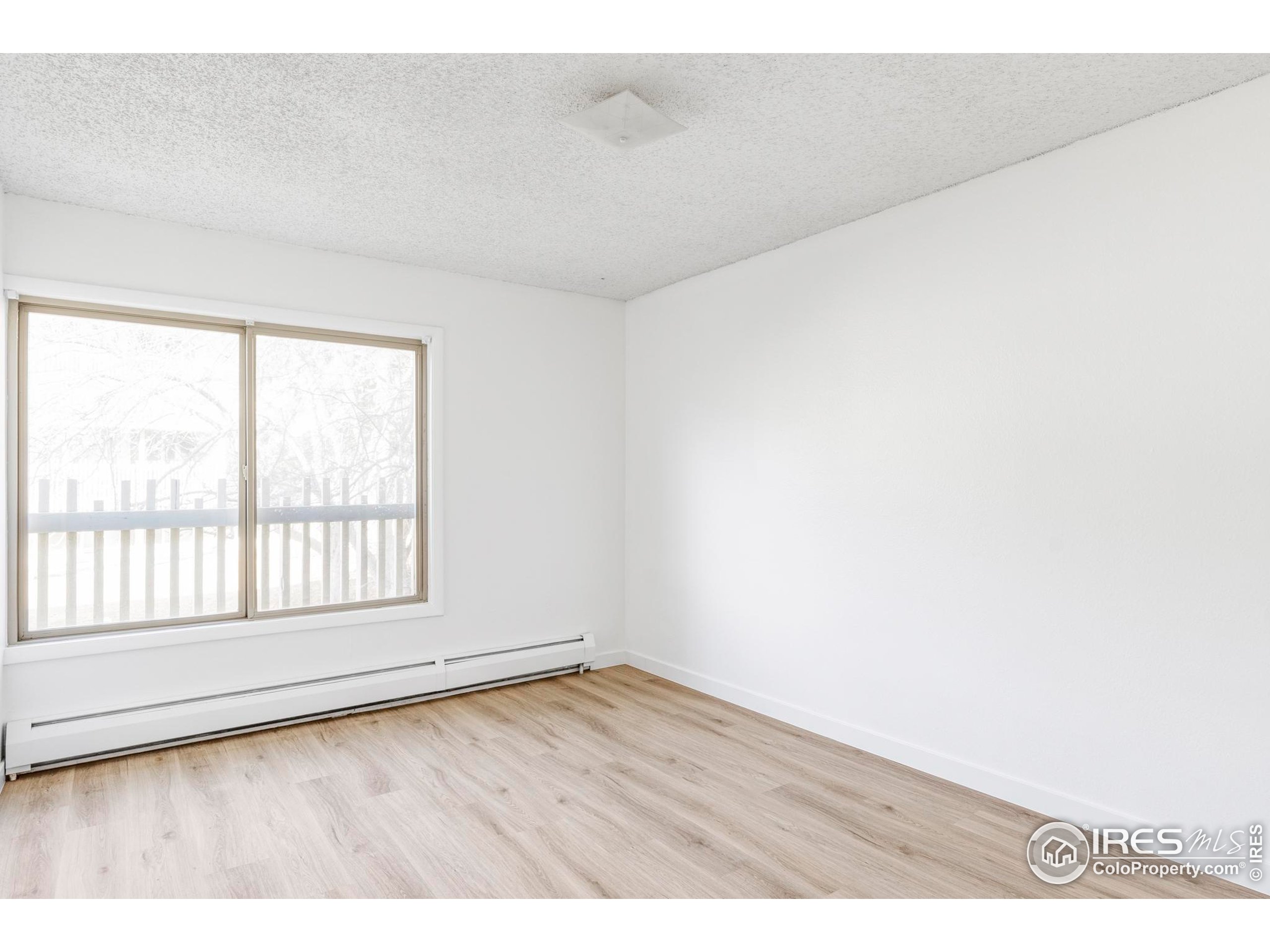 2707 Valmont Road, Unit 205D Boulder, CO 80304 - Photo 7 of 18 an empty room with wooden floor and windows