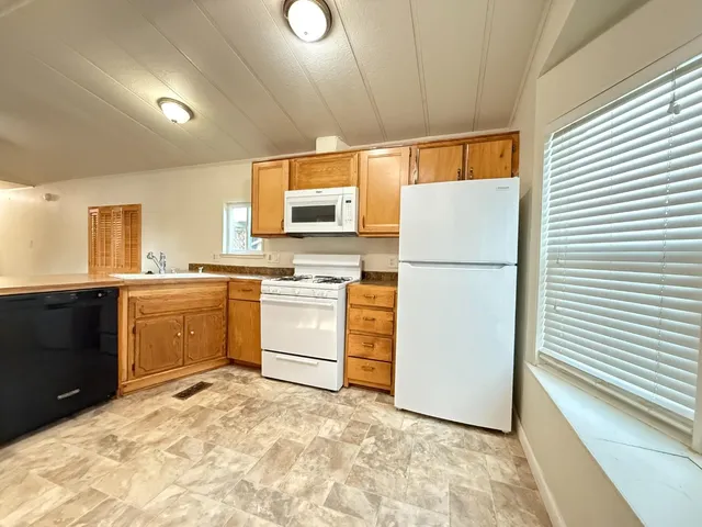 a kitchen with white cabinets and white appliances