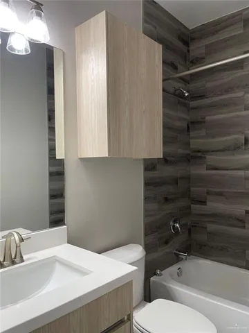 a bathroom with a sink toilet vanity and shower