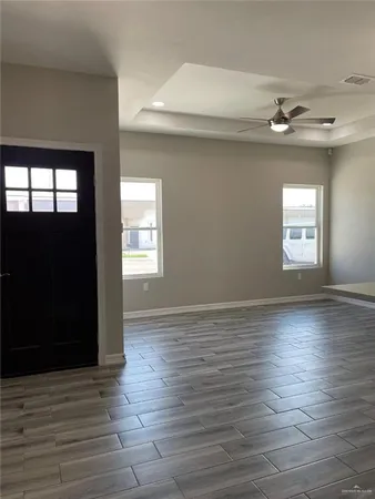 an empty room with wooden floor and windows