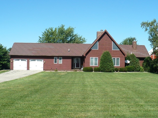 18430 East Twombly Road Rochelle, IL 61068 - Photo 1 of 25 a front view of a house with a yard and garage