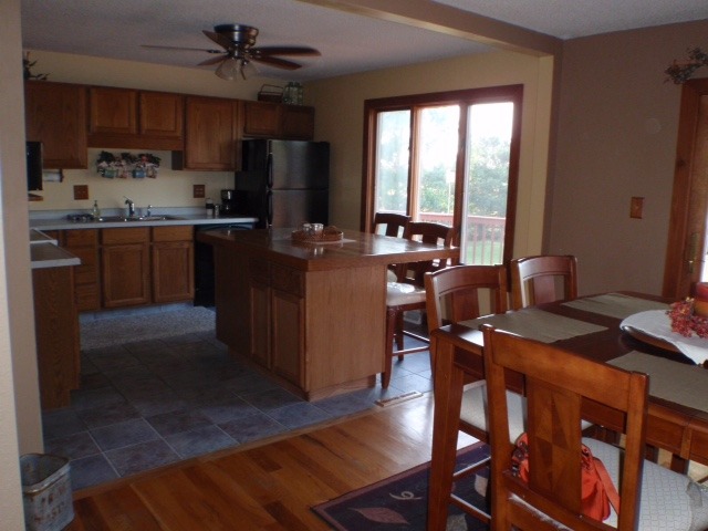 18430 East Twombly Road Rochelle, IL 61068 - Photo 6 of 25 a kitchen with stainless steel appliances granite countertop a stove a refrigerator a sink a dining table and chairs with wooden floor