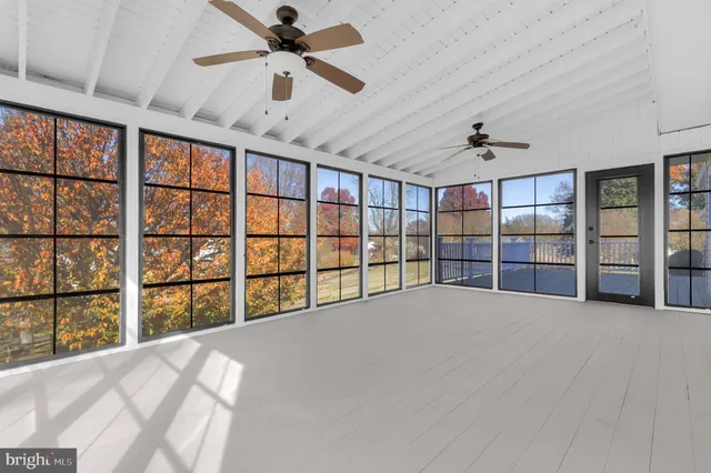 an empty room with a ceiling fan and window