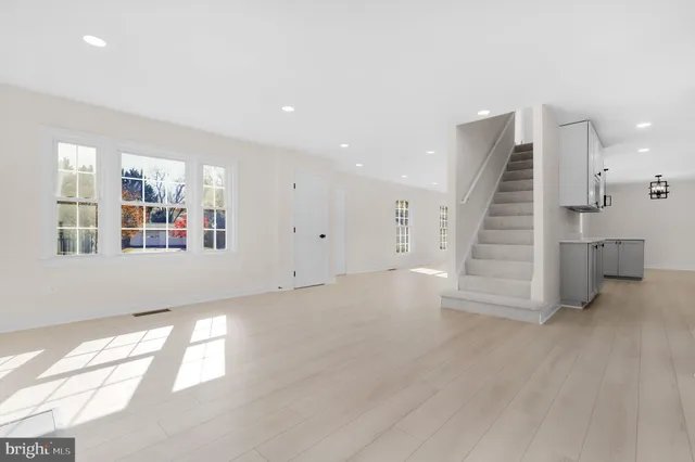 an empty room with windows and fireplace
