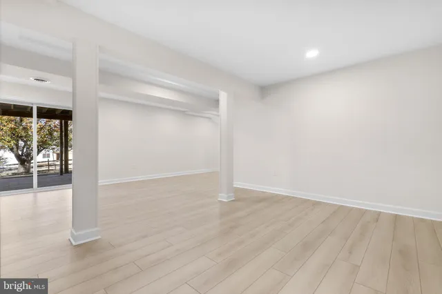 wooden floor in an empty room with a bathroom