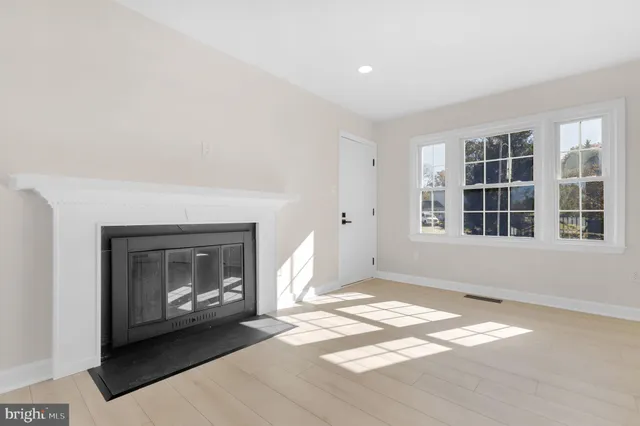 a view of an empty room with a fireplace and a window