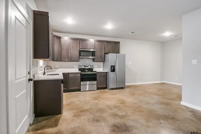 a kitchen with kitchen island a refrigerator sink and stove