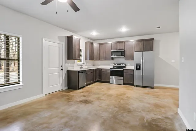 a large kitchen with cabinets and stainless steel appliances