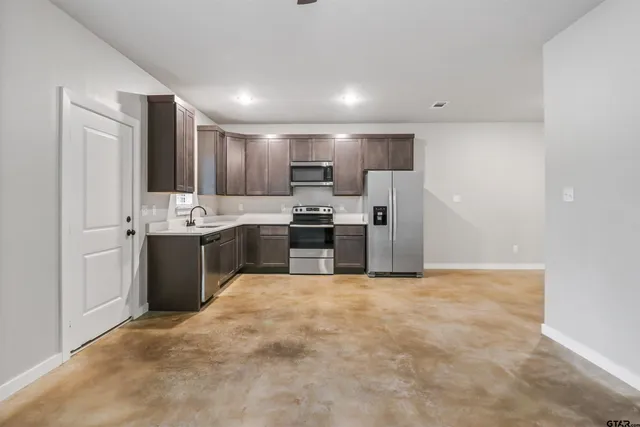 a large white kitchen with a stove a sink and a refrigerator