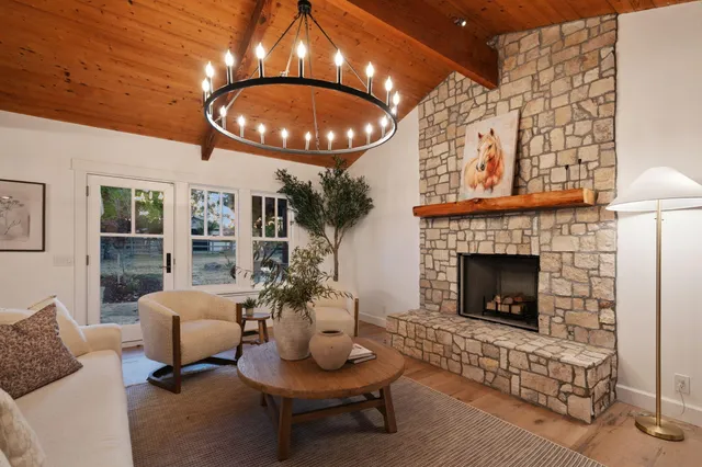 a living room with furniture a fireplace and a lamp