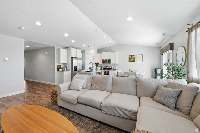 1175 Silver Hollow Road Syracuse, UT 84075 - Photo 7 of 34 Open-concept living space featuring wood-finish flooring, recessed lighting, white cabinetry, and stainless steel appliances